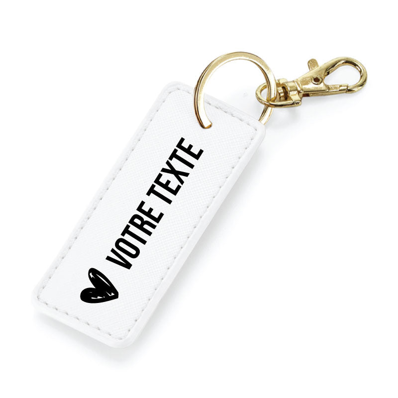 Porte-clés blanc en simili cuir avec anneau métallique or, finition élégante et message personnalisable.