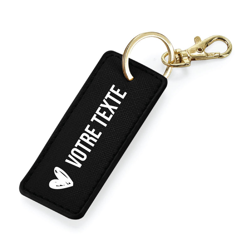 Porte-clés noir en simili cuir avec anneau métallique or, finition élégante et message personnalisable.