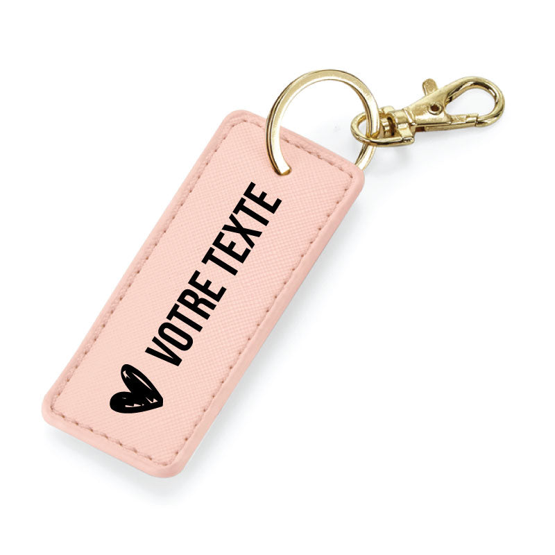 Porte-clés rose en simili cuir avec anneau métallique or, finition élégante et message personnalisable.